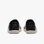 Black Vivobarefoot Primus Lite IV women's athletic shoes with light beige soles, rear view.