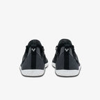 Pair of black knit athletic shoes with white soles, viewed from the back.