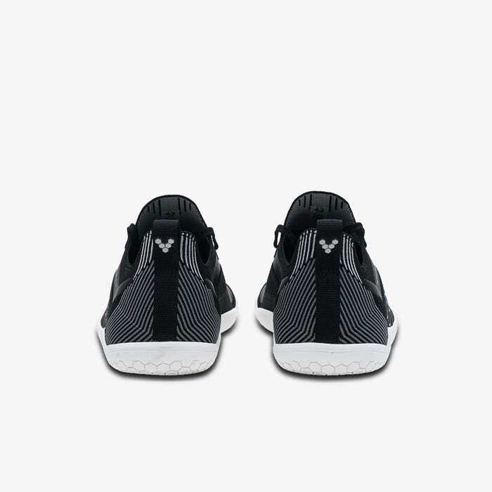 Pair of black knit athletic shoes with white soles, viewed from the back.