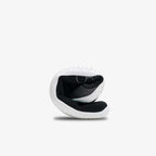 Black flexible knit sneaker folded to show sole and interior cushioning.
