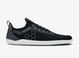 Black knitted low-profile athletic shoe with white sole and hexagonal side pattern.