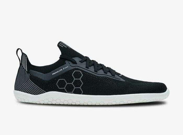 Black knitted low-profile athletic shoe with white sole and hexagonal side pattern.