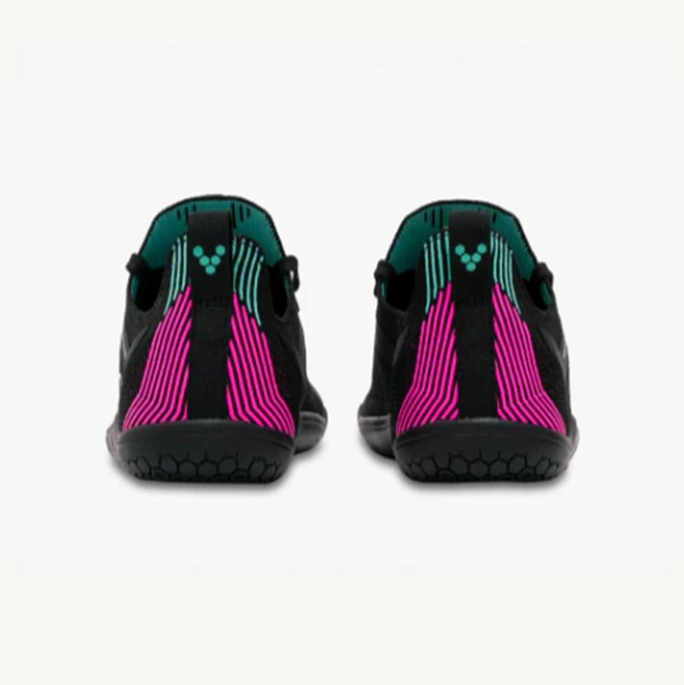 Vivobarefoot women's athletic shoes with black knit upper and vibrant pink vertical stripes on heel.