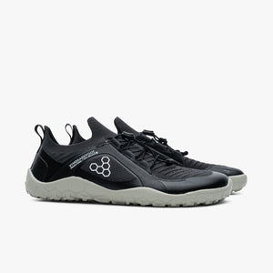 Black and dark gray Vivobarefoot Primus Trail Knit FG sneakers with textured soles and hexagonal logo on the side.