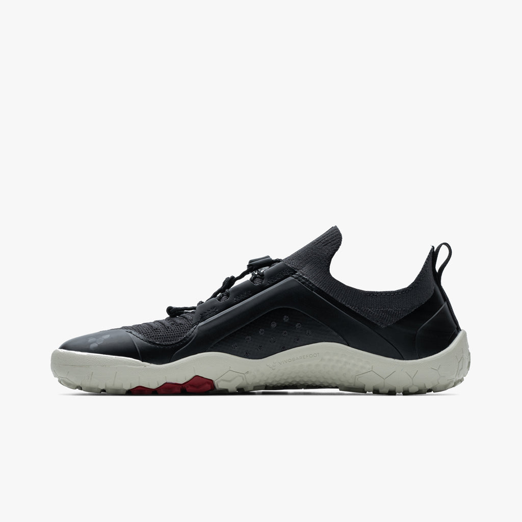 Black and gray low-profile athletic shoe with knit upper and textured white sole.