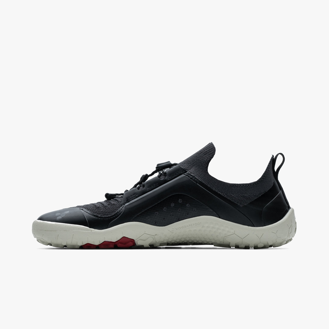 Black and gray low-profile athletic shoe with knit upper and textured white sole.