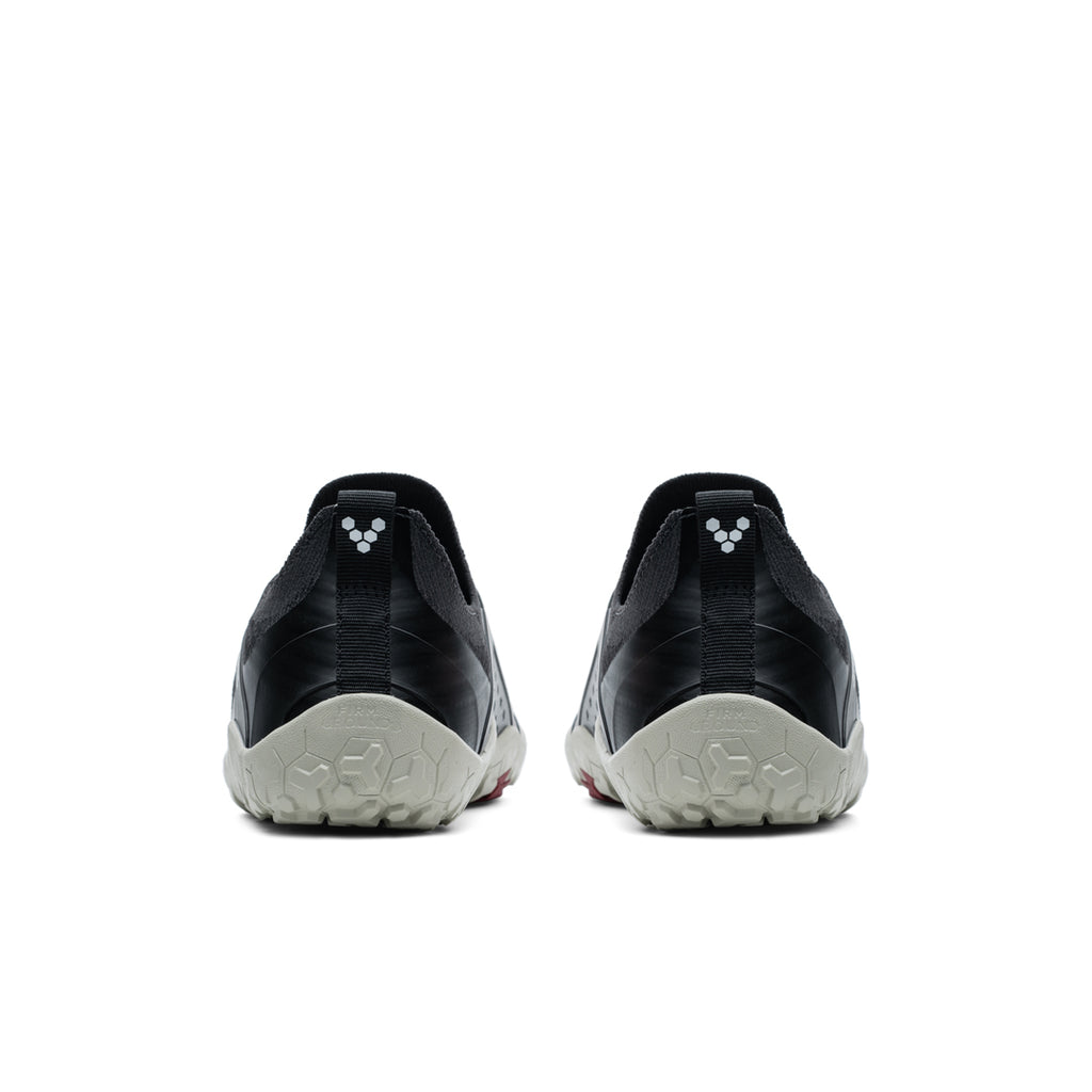 Pair of black and gray Vivobarefoot Primus Trail Knit FG shoes viewed from the back with textured sole and subtle logo.