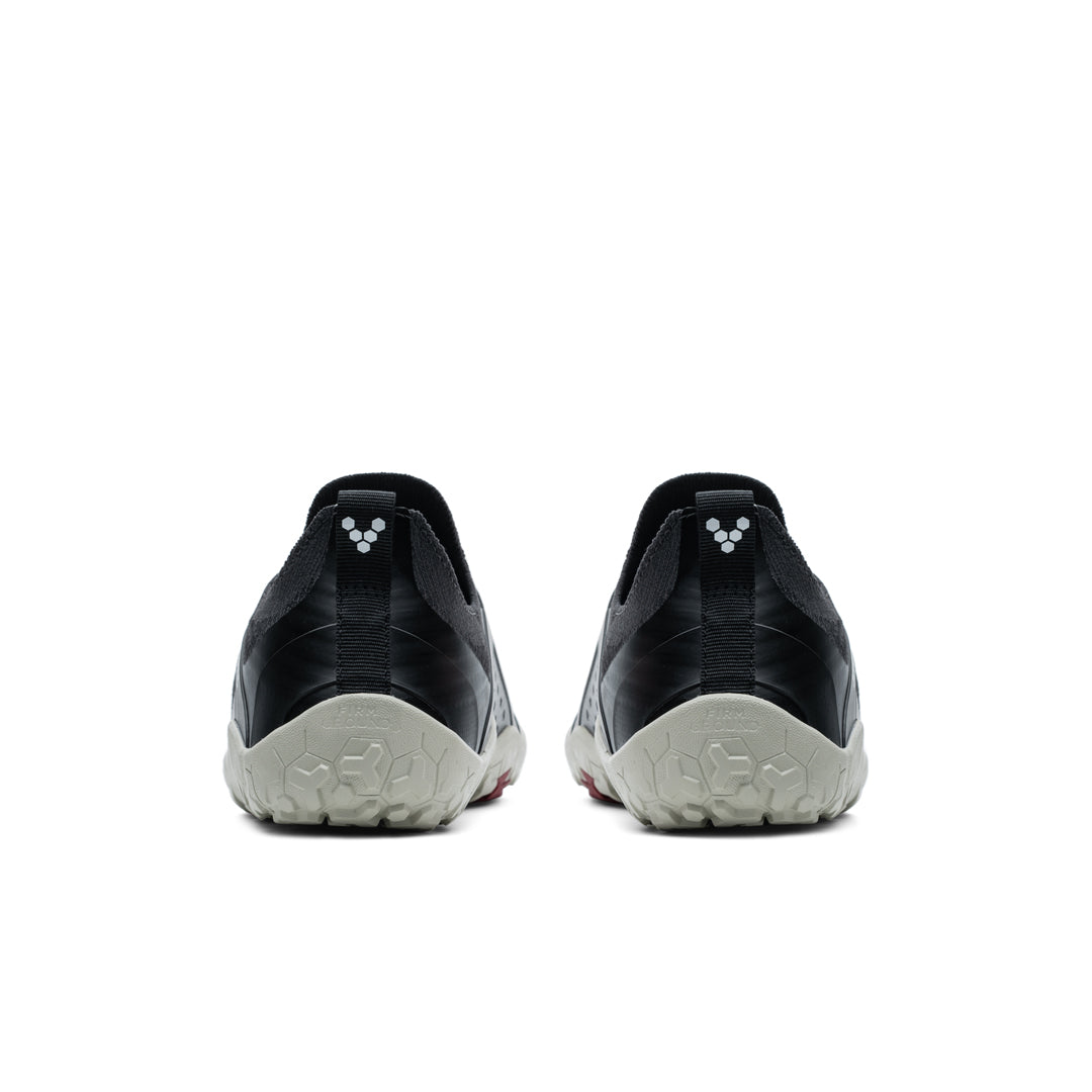 Pair of black and gray Vivobarefoot Primus Trail Knit FG shoes viewed from the back with textured sole and subtle logo.