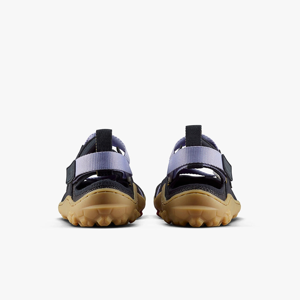 Pair of purple heather Vivobarefoot women's Tracker sandals with black straps and rugged tan soles shown from the back.