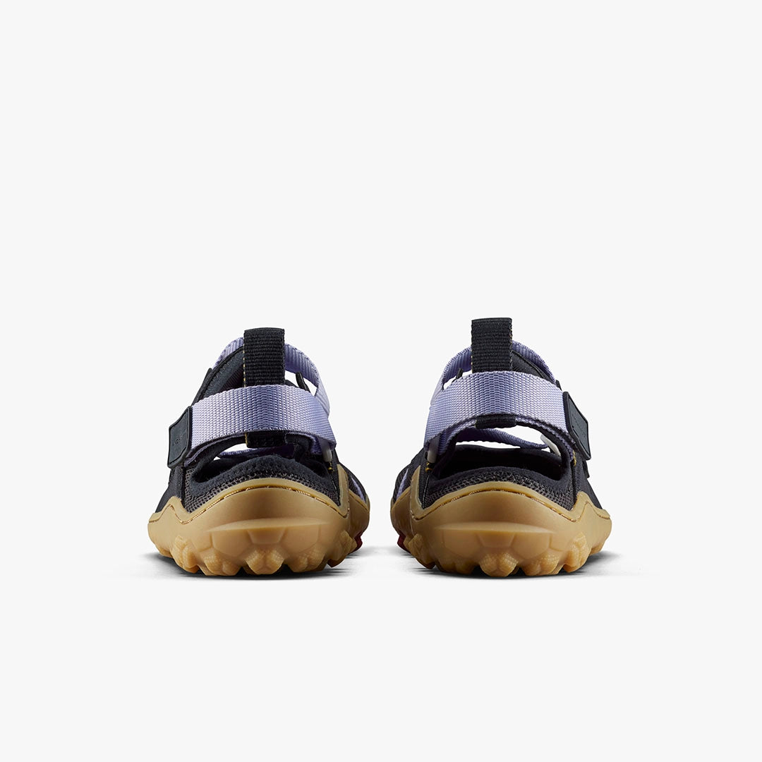 Pair of purple heather Vivobarefoot women's Tracker sandals with black straps and rugged tan soles shown from the back.