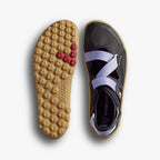Purple athletic sandal with crisscross straps and textured tan sole with red grip accents.