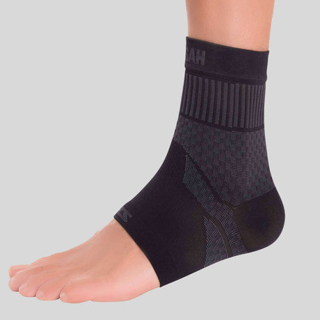 Black compression ankle sleeve with ribbed cuff and textured support panels on foot and ankle.