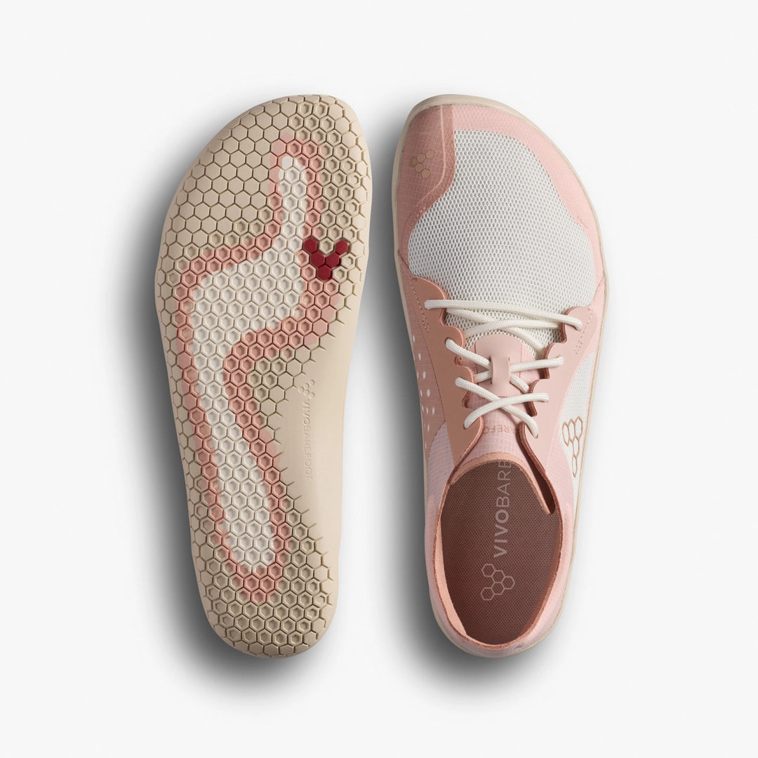 Pink athletic shoe with textured sole and brand logo on a light gray background